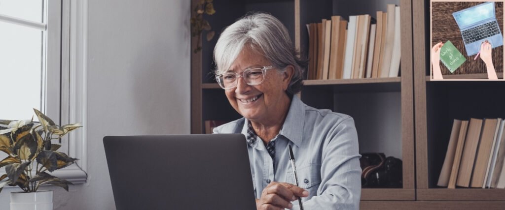 Grey-haired woman using a laptop and pen at home, illustrating an everyday setup for remote administrative work.